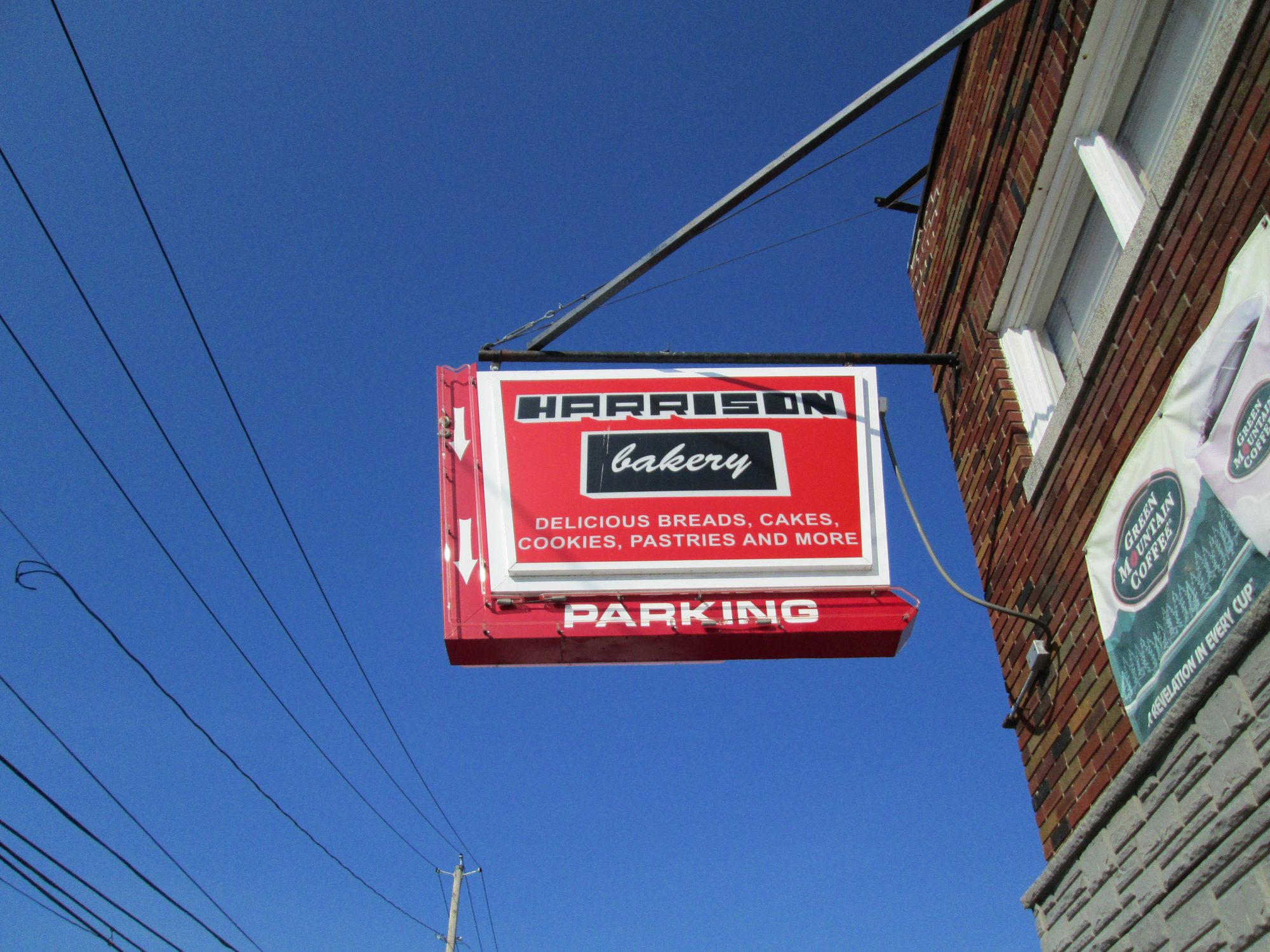 Harrison Bakery street sign: delicious breads, cakes, cookies, pastries and more